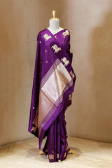 A purple Banarasi silk saree with Pichwai border for Navratri, Diwali, Durga Puja, and weddings, displayed on a mannequin.