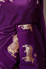 A purple Banarasi silk saree with Pichwai border closeup view