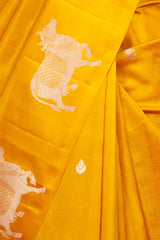 A yellow Banarasi silk saree with Pichwai zari border closeup