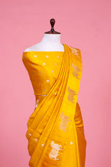 A yellow Banarasi silk saree with Pichwai zari border for Navratri, Diwali, Durga Puja, and weddings, displayed on a mannequin.