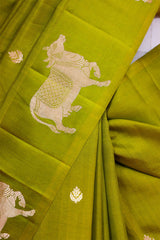 A henna green Banarasi silk saree with zari border, closeup Aghanya cow motif