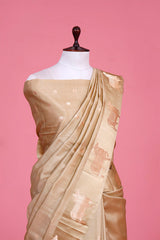 A beige Banarasi silk saree with gold zari border for Navratri, Diwali, Durga Puja, and weddings, displayed on a mannequin.
