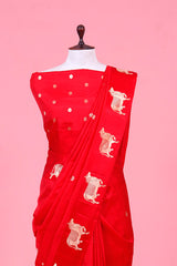 A rani red Banarasi silk saree with gold zari border for Navratri, Diwali, Durga Puja, and weddings, displayed on a mannequin.