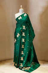 A green Banarasi silk saree with gold zari border for Navratri, Diwali, Durga Puja, and weddings, displayed on a mannequin.