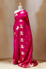 A rani pink Banarasi silk saree with gold zari border for Navratri, Diwali, Durga Puja, and weddings, displayed on a mannequin.