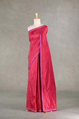 Red saree with a purple border on a mannequin against a gray background