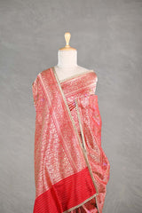 Red Banarasi silk saree with light gold intricate woven brocade patterns draped on a mannequin against a gray background