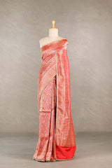 Red saree with gold patterns on a mannequin against a neutral background