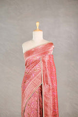 Red Banarasi silk saree with light gold intricate woven brocade patterns draped on a mannequin against a gray background
