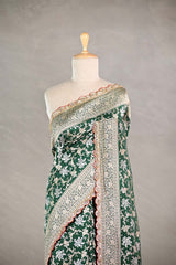 Bottle Green Banarasi silk saree with silver-gold intricate woven patterns draped on a mannequin against a gray background