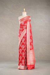Red Banarasi silk saree with light gold floral woven patterns draped on a mannequin against a gray background