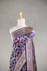 Red Banarasi silk saree with light gold intricate Pichwai woven patterns draped on a mannequin against a gray background