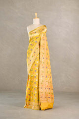 Yellow Banarasi silk saree with multicolor floral patterns draped on a mannequin against a neutral background