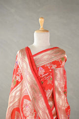 Red Banarasi silk saree with floral patterns on a mannequin against a plain background