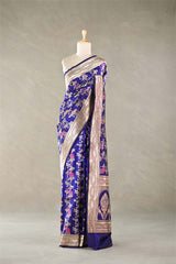 Blue silk saree with floral patterns on a mannequin against a neutral background