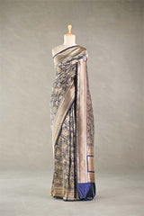 Navy Blue Banarasi silk saree with light gold intricate woven patterns draped on a mannequin against a gray background