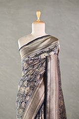Navy Blue Banarasi silk saree with light gold intricate woven patterns draped on a mannequin against a gray background