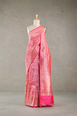 Pink silk saree with intricate patterns on a mannequin against a gray background
