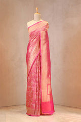 Pink saree with a subtle pattern on a mannequin against a plain background