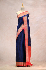 Navy blue saree with red border on a mannequin against a neutral background
