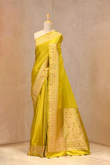 Close up of Chartuese Green Semi Satin Silk Saree showing gold zari woven polka butis and a Paithani-style Meenakari border.