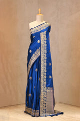 Close up of Royal Blue Semi Satin Silk Saree showing gold zari woven pakshi motifs and a Mrigvan-inspired deer and tree border.