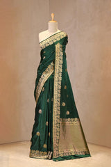 Close up of Bottle Green Semi Satin Silk Saree showing gold zari woven pakshi motifs and a Mrigvan-inspired deer and tree border.
