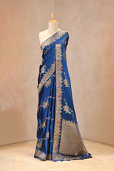 Close up of Teal Blue Semi Satin Silk Saree showing gold zari floral vines in a diagonal Leheriya pattern with resham woven pakshi motifs.