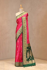Close up of Pink and Green Semi Satin Silk Saree showing gold zari woven rose buti on white body and gold zari floral patterns on contrasting pink border.