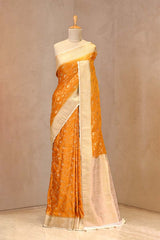 Close up of Yellow Semi Satin Silk Saree showing gold zari woven floral jaal on yellow body and gold zari floral patterns on contrasting border.