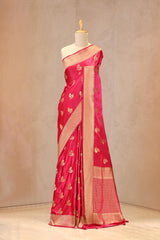 Close up of Magenta Pink Semi Satin Silk Saree showing gold zari woven bird motifs with Meenakari detailing and gold zari brocade border.