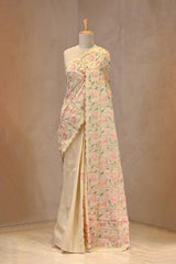 Close up of Beige Semi Tussar Silk Saree showing multicolor floral embroidered jaal across the body and a scalloped resham woven border.