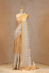 Close up of Mustard Semi-Silk Saree showing water gold zari butis on the body and a Madhubani printed border featuring folk-art figures.