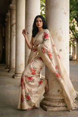 Woman in a floral saree standing next to a columned building