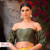 Woman wearing a green patterned blouse with a blurred floral background