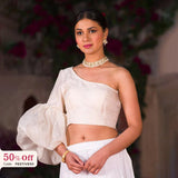 Woman wearing a white saree with a blurred background and promotional text overlay.