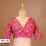 Pink patterned blouse on a mannequin with a brown background