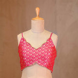 Red floral crop top on a mannequin against a brown background