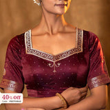 Woman wearing a maroon bridal blouse with gold embroidery with a promotional text Diwali sale offer on blouses up to 50%