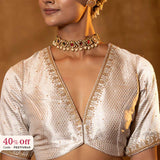 A woman wearing a traditional blouse with intricate designs with a promotional text Diwali sale offer on blouses up to 50%