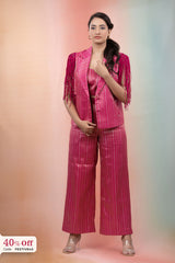 Woman wearing a pink striped outfit with a jacket and pants on a gradient background