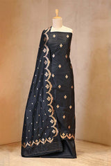 Black saree with gold embroidery on a mannequin against a beige background