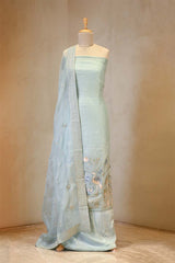 Light blue saree with intricate designs on a mannequin against a beige background