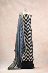 Alternating zig-zag gold zari woven stripe patterns with intricate meenakari floral detailing on a black Banarasi silk unstitched suit set.