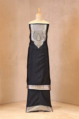 Black dress with silver embroidery on a mannequin against a beige background