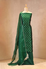 Green saree with a matching blouse on a mannequin against a beige background