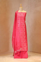 Pink traditional outfit with white embroidery on a mannequin against a beige background