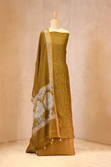 mustard suit set with intricate patterns on a mannequin against a beige background