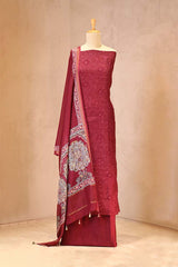 maroon traditional outfit with a patterned dupatta on a mannequin against a beige background