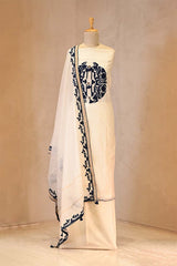 White saree with Blue floral patterns on a mannequin against a beige background